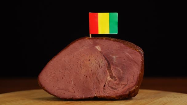 紅肉の一部に装飾的なGuinean旗のつまようじを置く人. — ストック動画