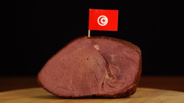 Person placing decorative Tunisian flag toothpicks into piece of red meat. — Stock Video