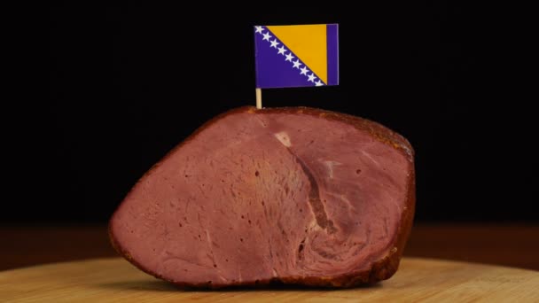 Persona que coloca palillos decorativos de la bandera bosnia en un trozo de carne roja. — Vídeo de stock