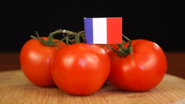 Mann legt dekorativen Zahnstocher mit Frankreich-Flagge in Tomatenbüschel. — Stockvideo