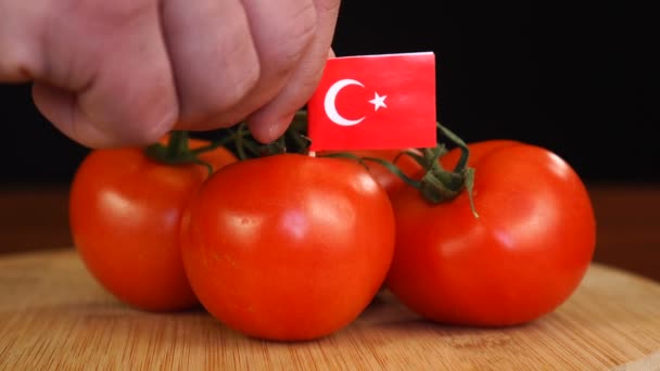 Homem colocando palito decorativo com bandeira da Turquia em um monte de tomates. — Vídeo de Stock