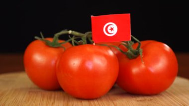 Tunus bayrağıyla dekoratif kürdanı domates demetine yerleştiren adam..