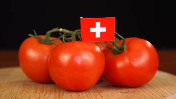 Homme plaçant cure-dent décoratif avec drapeau de la Suisse dans un bouquet de tomates. — Video