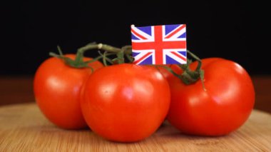 Büyük Britanya bayrağıyla dekoratif kürdanı domates demetine yerleştiren adam..