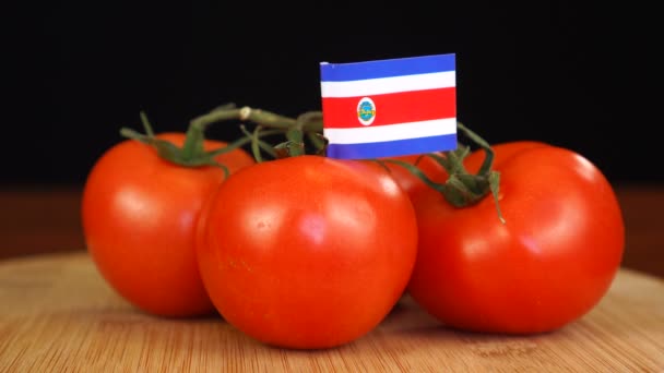 Hombre colocando palillo decorativo con bandera de Costa Rica en manojo de tomates. — Vídeos de Stock