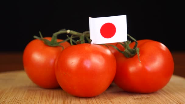 Hombre colocando palillo decorativo con bandera de Japón en un ramo de tomates. — Vídeo de stock