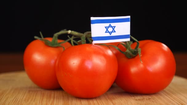 Hombre colocando palillo decorativo con la bandera de Israel en un montón de tomates. — Vídeo de stock