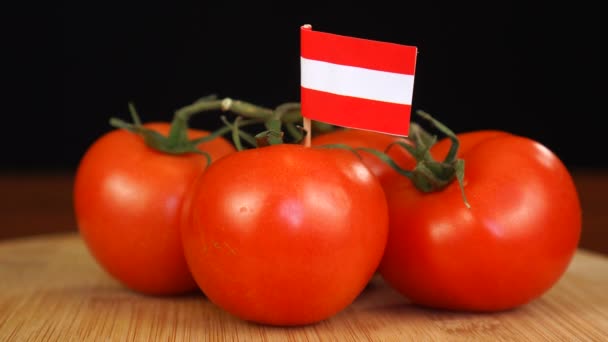Man plaatst decoratieve tandenstoker met vlag van Oostenrijk in tros tomaten. — Stockvideo
