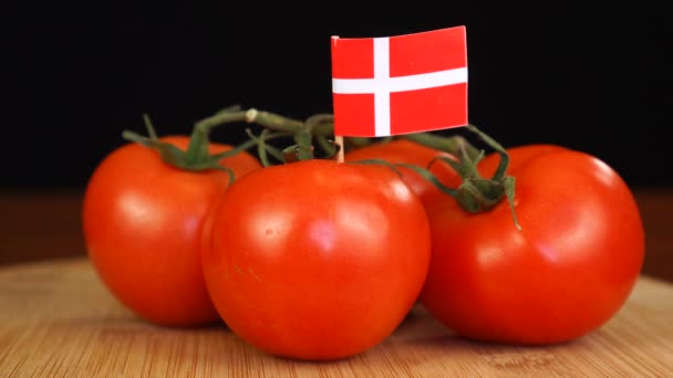 Hombre colocando palillo decorativo con bandera de Dinamarca en un ramo de tomates. — Vídeo de stock