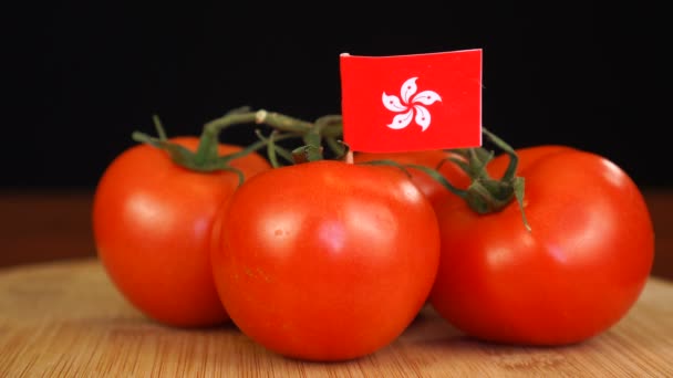 Homme plaçant cure-dent décoratif avec drapeau de Hong Kong dans un bouquet de tomates. — Video