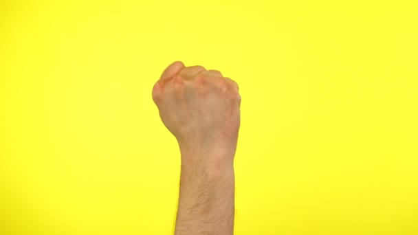 Mans puño golpeando la puerta gesto golpe-golpe que hay sobre un fondo amarillo. — Vídeo de stock