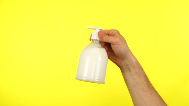 Flacon de désinfectant pour les mains avec distributeur isolé sur fond jaune — Video