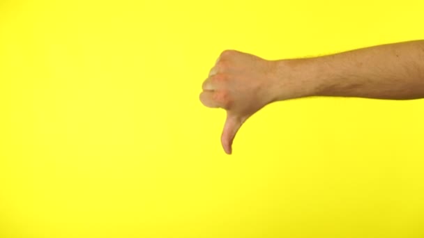 Человек показывает большой палец вниз, потерять жест изолирован на желтом фоне. Концепция неприятия. — стоковое видео