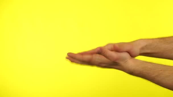 Händerna klappar och visar på gul bakgrund — Stockvideo