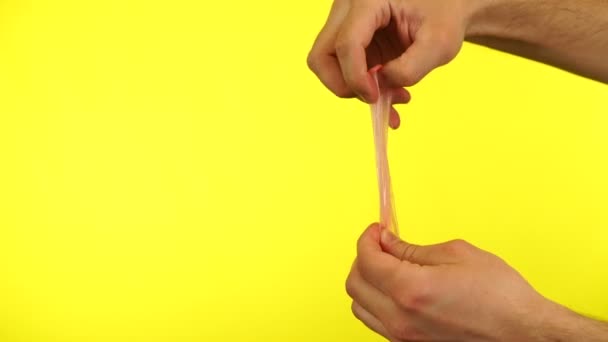 사람은 노란 배경에 고립된 콘돔을 손으로 쥐고 있다. 손을 감고 찍은 영상만. — 비디오