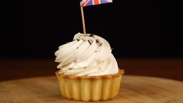 Man places decorative toothpick with flag of Great Britain into cream cake. National cuisine — Stock Video