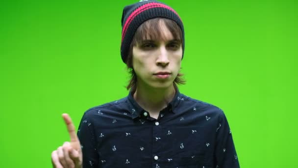 Ung man gör avvisa symbol mot en löstagbar kroma nyckel bakgrund — Stockvideo