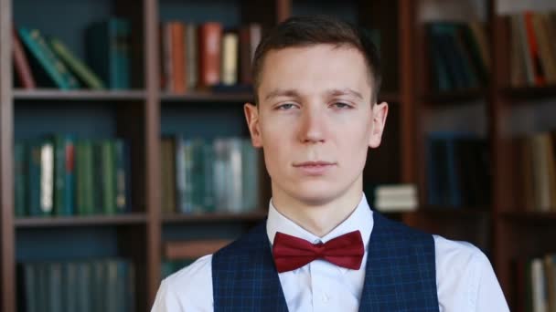 Handsome white man standing in university library looking at camera and smiling — Stock Video