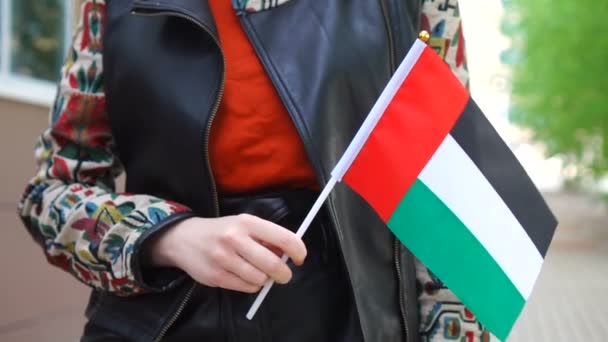 Onherkenbare vrouw met de vlag van de VAE. Meisje loopt door straat met de nationale vlag van de Verenigde Arabische Emiraten — Stockvideo