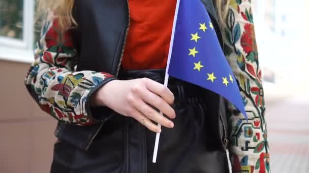 Mulher irreconhecível com bandeira europeia. Menina andando rua abaixo com bandeira nacional da União Europeia. — Vídeo de Stock