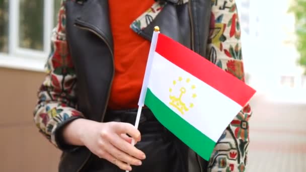 타지크 깃발을 들고 있는 알아볼 수없는 여성. 타지키스탄 국기를 들고 거리를 걷고 있는 소녀 — 비디오