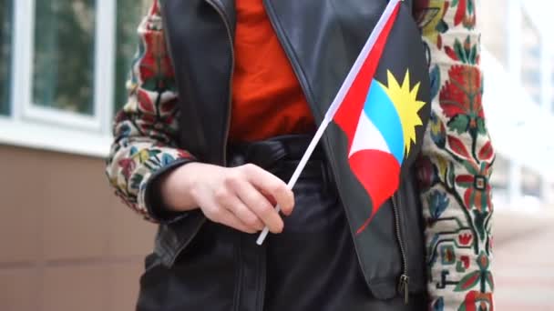 Neznámá žena držící Antiguu a Barbudovu vlajku. Dívka kráčí po ulici s národní vlajkou Antigua a Barbuda — Stock video