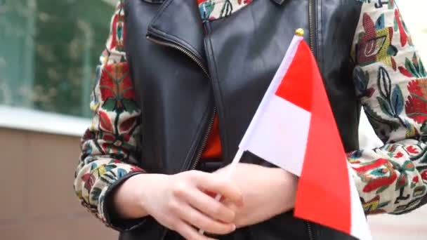 Vrouw die door straat loopt met de nationale vlag van Monaco of Indonesië — Stockvideo