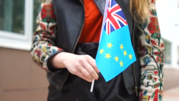 Tuvalu bayrağı tutan tanınmayan bir kadın. Tuvalu 'nun ulusal bayrağıyla sokakta yürüyen bir kız. — Stok video