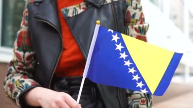 Elinde Bosna bayrağı tutan tanınmayan bir kadın. Bosna-Hersek bayrağıyla sokakta yürüyen bir kız