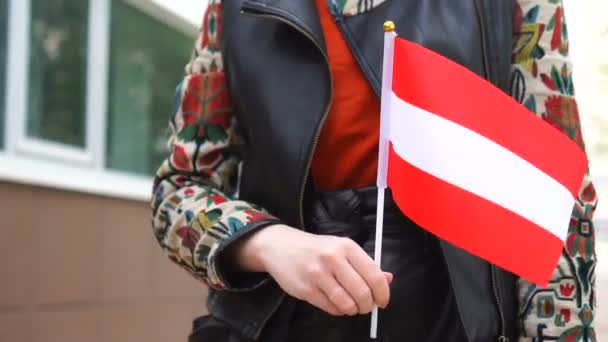 Nierozpoznana kobieta trzymająca austriacką flagę. Dziewczyna idzie ulicą z flagą narodową Austrii — Wideo stockowe