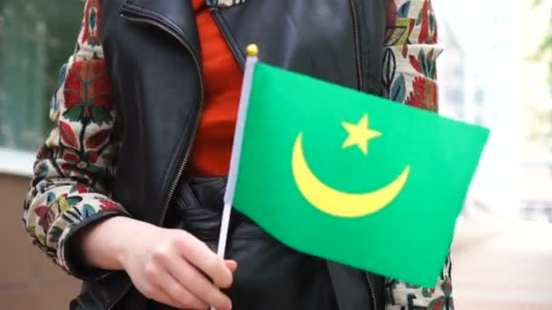 Oigenkännlig kvinna med mauretansk flagg. Flicka gå ner gatan med nationell flagga Mauretanien — Stockvideo
