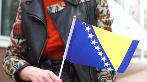 Donna irriconoscibile con bandiera bosniaca. Ragazza che cammina per strada con la bandiera nazionale di Bosnia Erzegovina — Video Stock