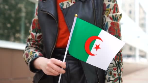 Unrecognizable woman holding Algerian flag. Girl walking down street with national flag of Algeria — Vídeos de Stock