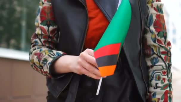 Neznámá žena držící Zambijskou vlajku. Dívka kráčející po ulici s národní vlajkou Zambii — Stock video