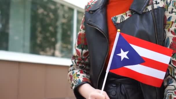 Неузнаваемая женщина с флагом Пуэрто-Рико. Девушка идет по улице с национальным флагом Пуэрто-Рико — стоковое видео