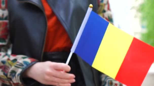 Unrecognizable woman holding Romanian flag. Girl walking down street with national flag of Romania — Vídeo de stock