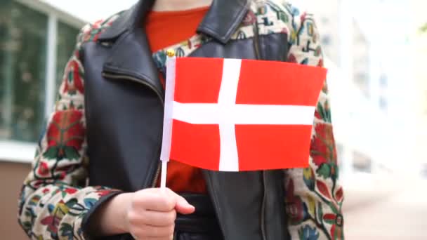 Unrecognizable woman holding Danish flag. Girl walking down street with national flag of Denmark — Vídeos de Stock