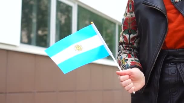Nierozpoznana kobieta z argentyńską flagą. Dziewczyna idąca ulicą z flagą Argentyny — Wideo stockowe
