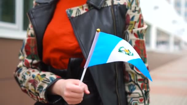 Mulher irreconhecível segurando bandeira guatemalteca. Menina andando rua abaixo com bandeira nacional da Guatemala — Vídeo de Stock