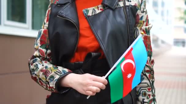 Unrecognizable woman holding Azerbaijani flag. Girl walking down street with national flag of Azerbaijan — Vídeos de Stock
