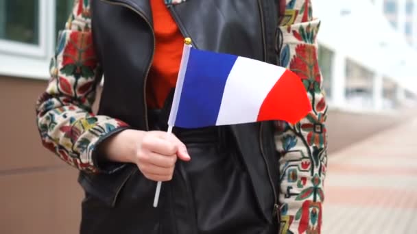 Oigenkännlig kvinna med fransk flagga. Flicka promenader ner gatan med nationell flagga i Frankrike — Stockvideo