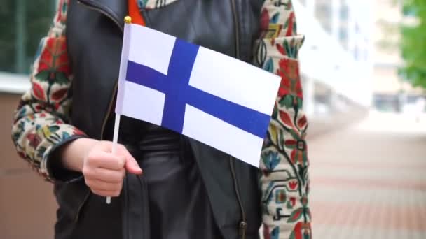 Felismerhetetlen nő, finn zászlóval. Lány sétál az utcán a nemzeti zászló Finnország — Stock videók