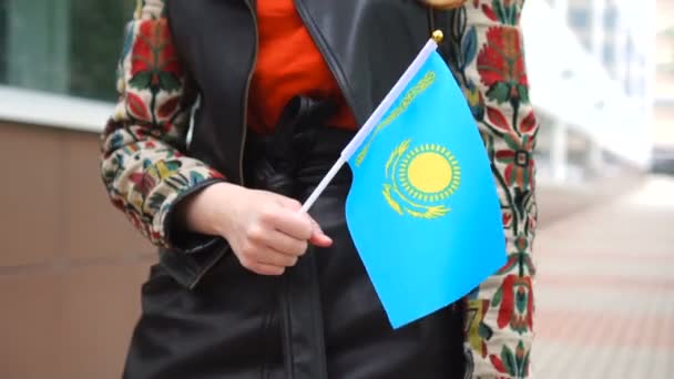 Mulher irreconhecível segurando a bandeira do Cazaquistão. Menina andando rua abaixo com bandeira nacional do Cazaquistão — Vídeo de Stock