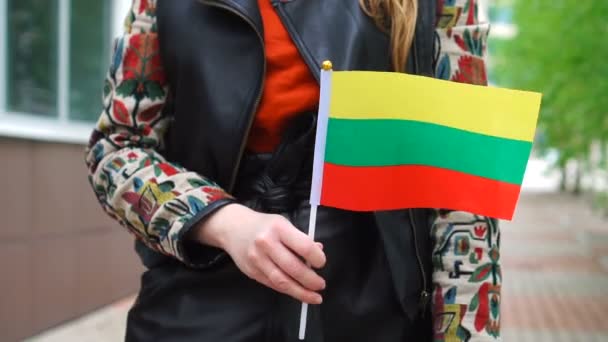 Mulher irreconhecível segurando bandeira lituana. Menina andando rua abaixo com bandeira nacional da Lituânia — Vídeo de Stock