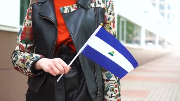 Unrecognizable woman holding Nicaraguan flag. Girl walking down street with national flag of Nicaragua — Stock Video