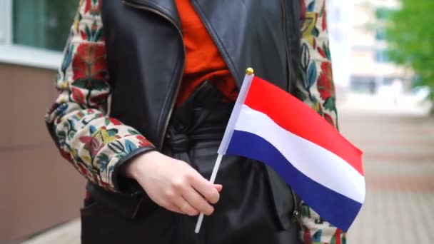네덜란드 국기를 들고 있는 알아볼 수없는 여성. 네덜란드 국기를 들고 거리를 걷고 있는 소녀 — 비디오