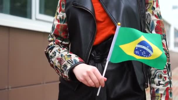 ブラジル国旗を掲揚している。ブラジルの国旗を掲げて街を歩く少女 — ストック動画
