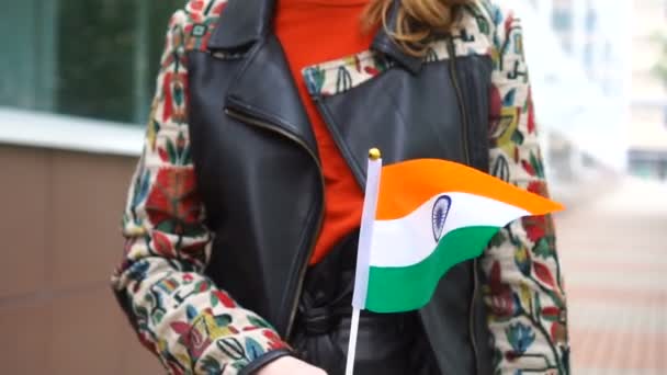 Невпізнавана жінка, що тримає індійський прапор. Дівчина йде по вулиці з національним прапором Індії. — стокове відео