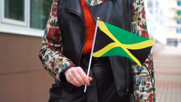 Onherkenbare vrouw met Jamaicaanse vlag. Meisje loopt door straat met de nationale vlag van Jamaica — Stockvideo