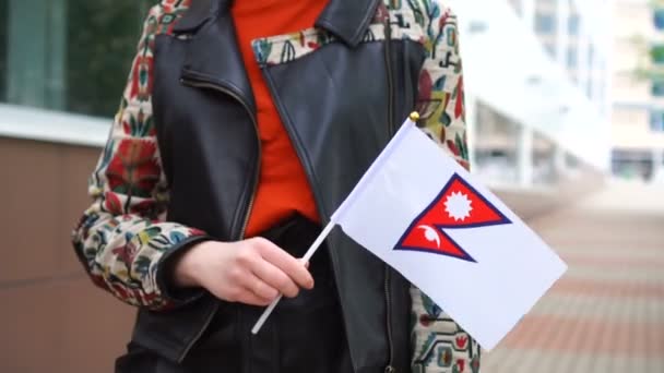 Unrecognizable woman holding Nepali flag. Girl walking down street with national flag of Nepal — Vídeos de Stock
